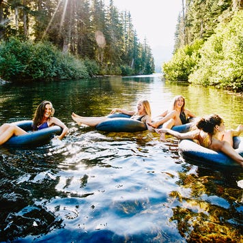 group of friends tubing on the river in summer