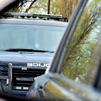 A police car has a motorist stopped for a violation. the drivers