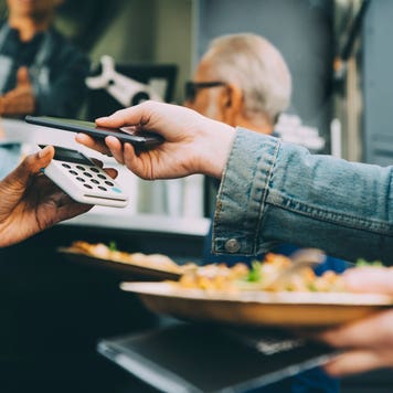 close up of hands making contactless payment using phone