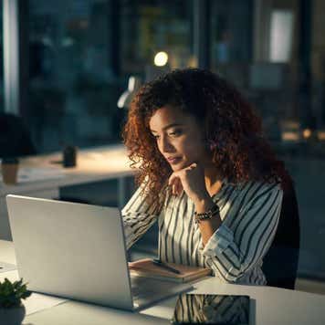 Shot of a young businesswoman using a laptop during a late night at work