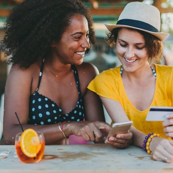 Happy women on beach holiday shopping online