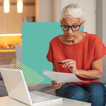 Older woman sitting on a couch, reviewing papers