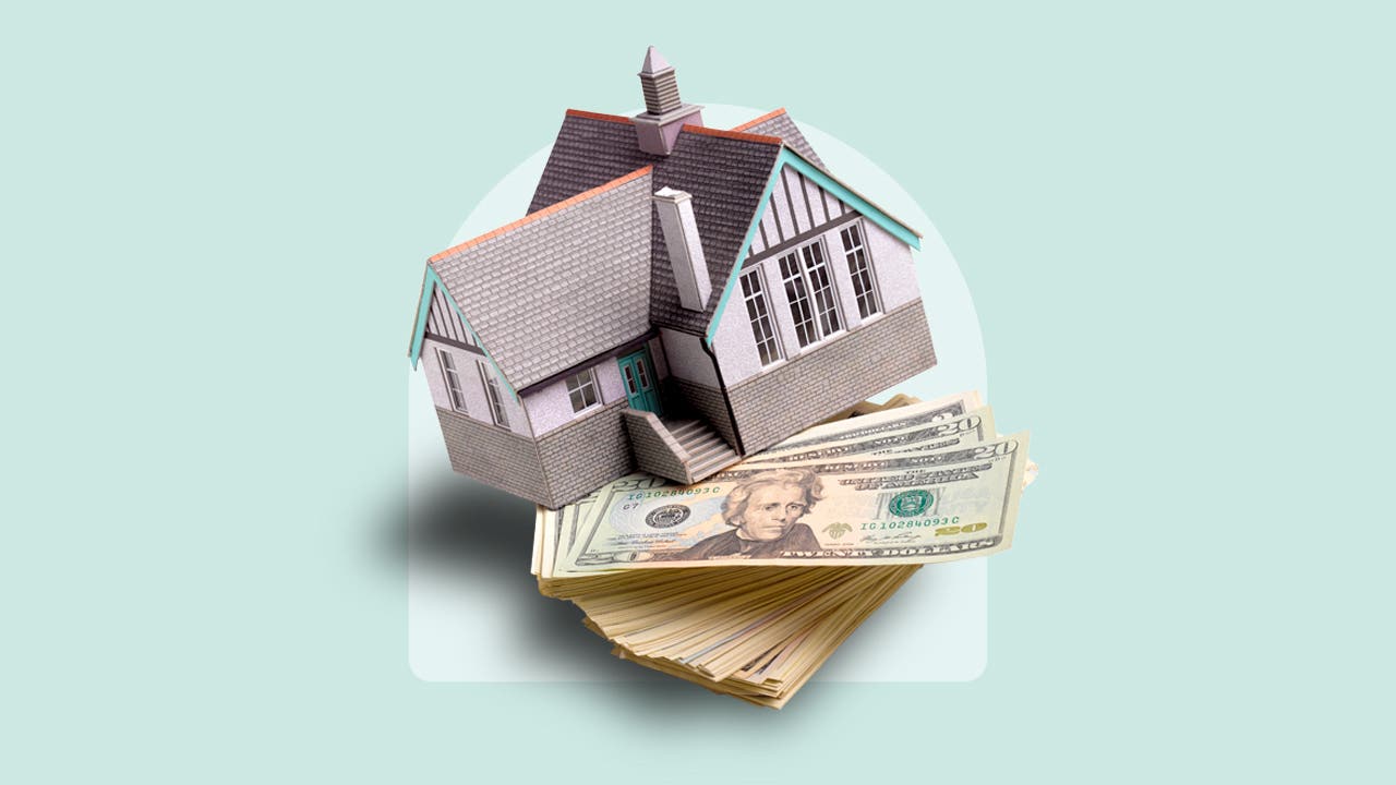 photo illustration of house balanced on stack of cash, light blue background