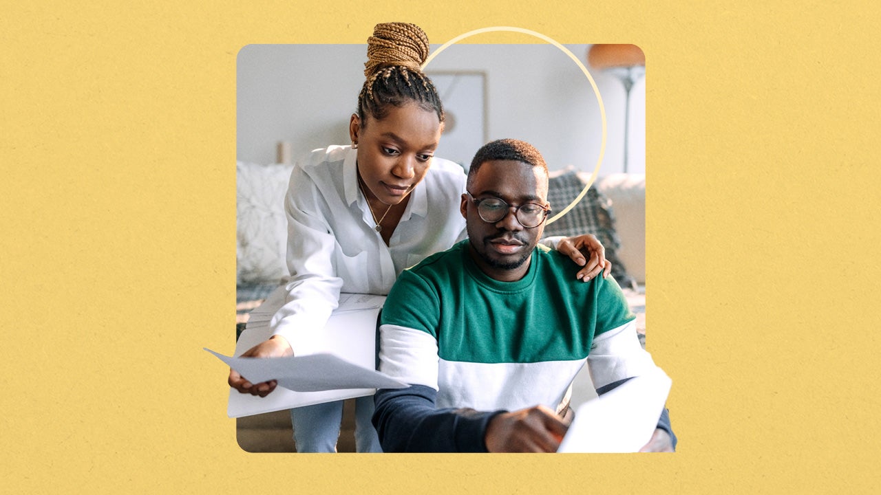 Black man and woman reviewing papers in their living room with a yellow square border and thin yellow circle behind them