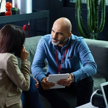 A financial advisor sits with a client going over some records.
