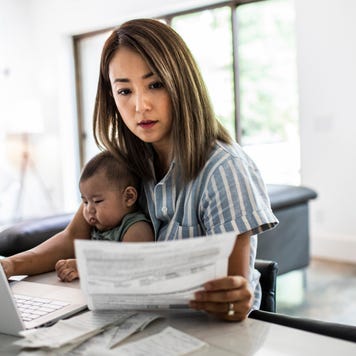 Mother holding a baby while looking at documents
