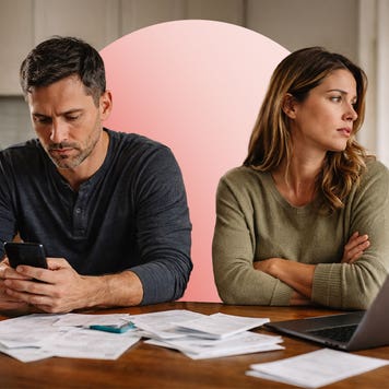A man and woman sit on couch looking away from one another.