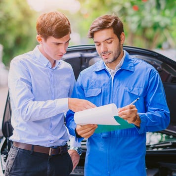 A car mechanic consulting with a client
