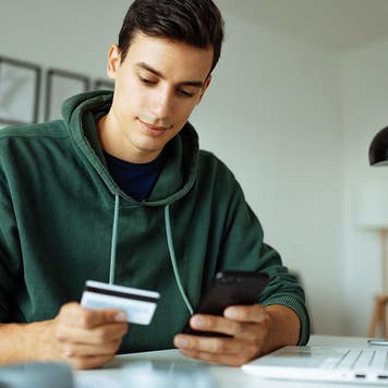 Man using credit card and mobile phone to make payment