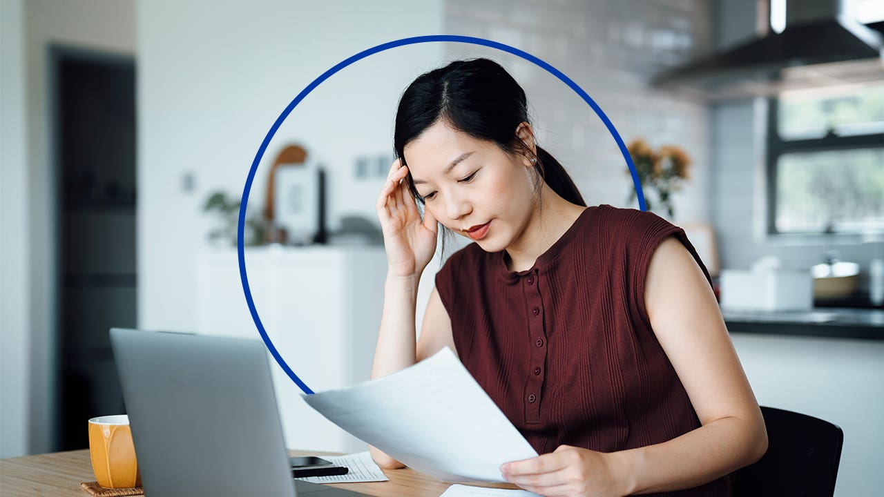 An Asian woman looks at paperwork