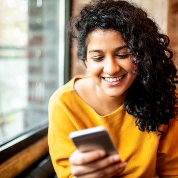 Woman using mobile phone at the bar