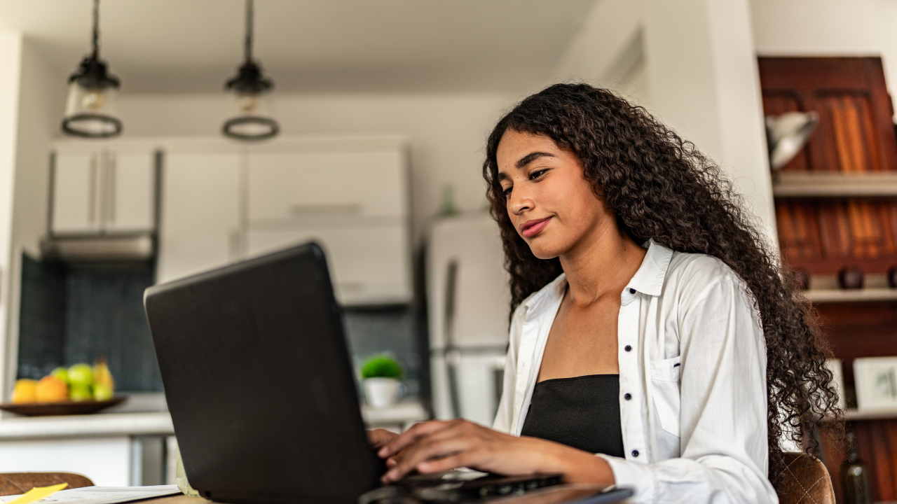 Young woman doing her finances on her laptop at home.